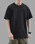 man wearing black t-shirt with oversized drop shoulder design, heavyweight 100% cotton fabric