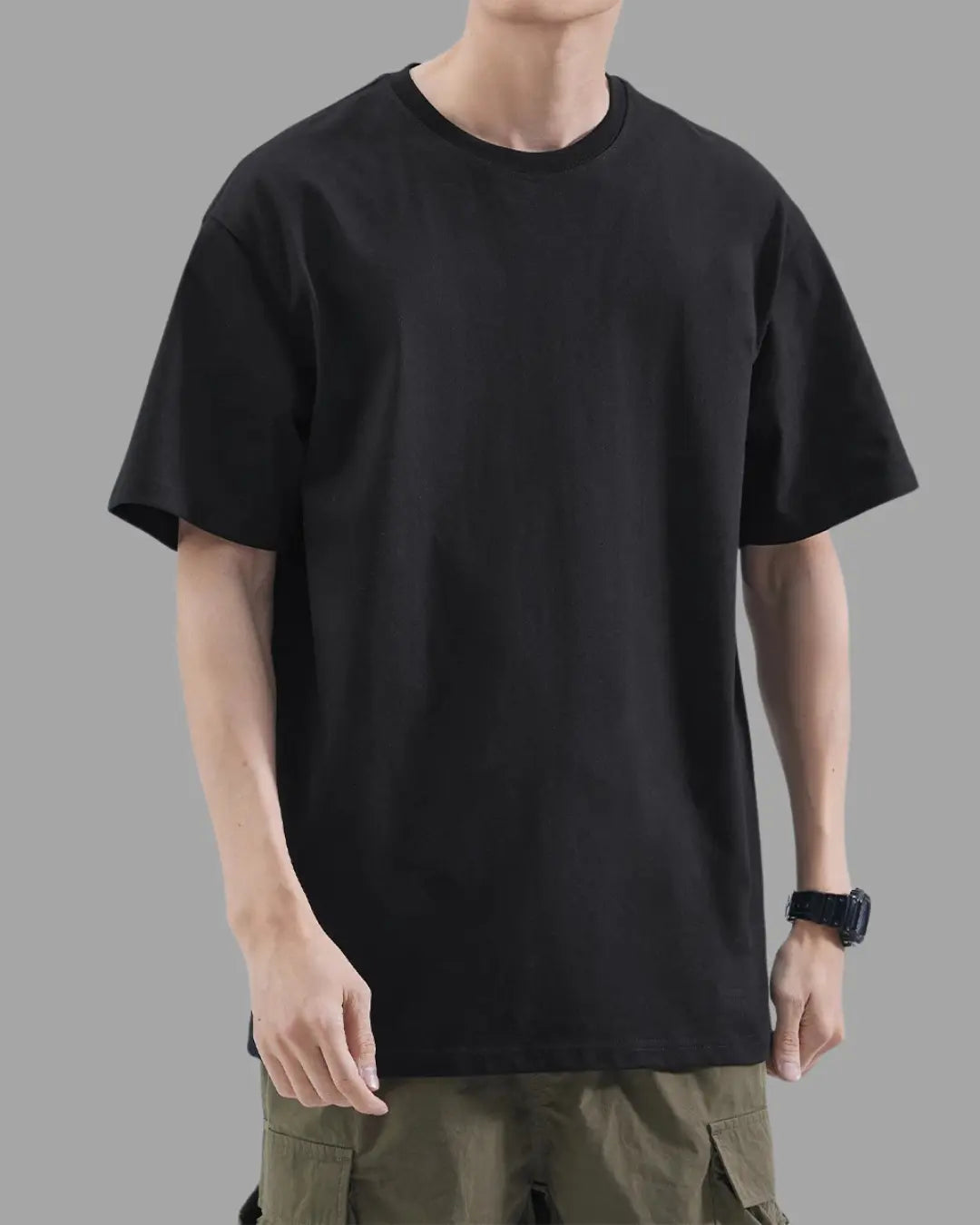 man wearing black t-shirt with oversized drop shoulder design, heavyweight 100% cotton fabric