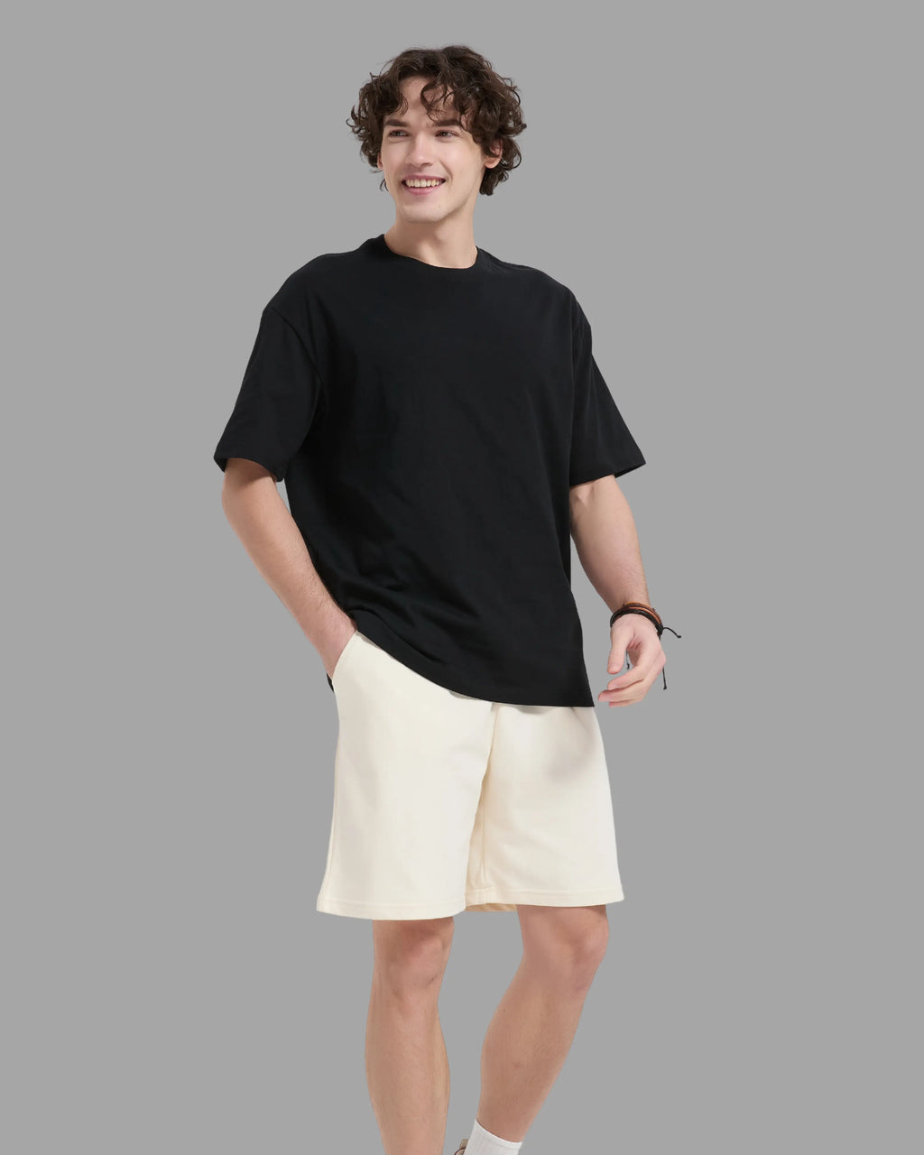 man wearing black t-shirt with oversized drop shoulder design, heavyweight 100% cotton fabric