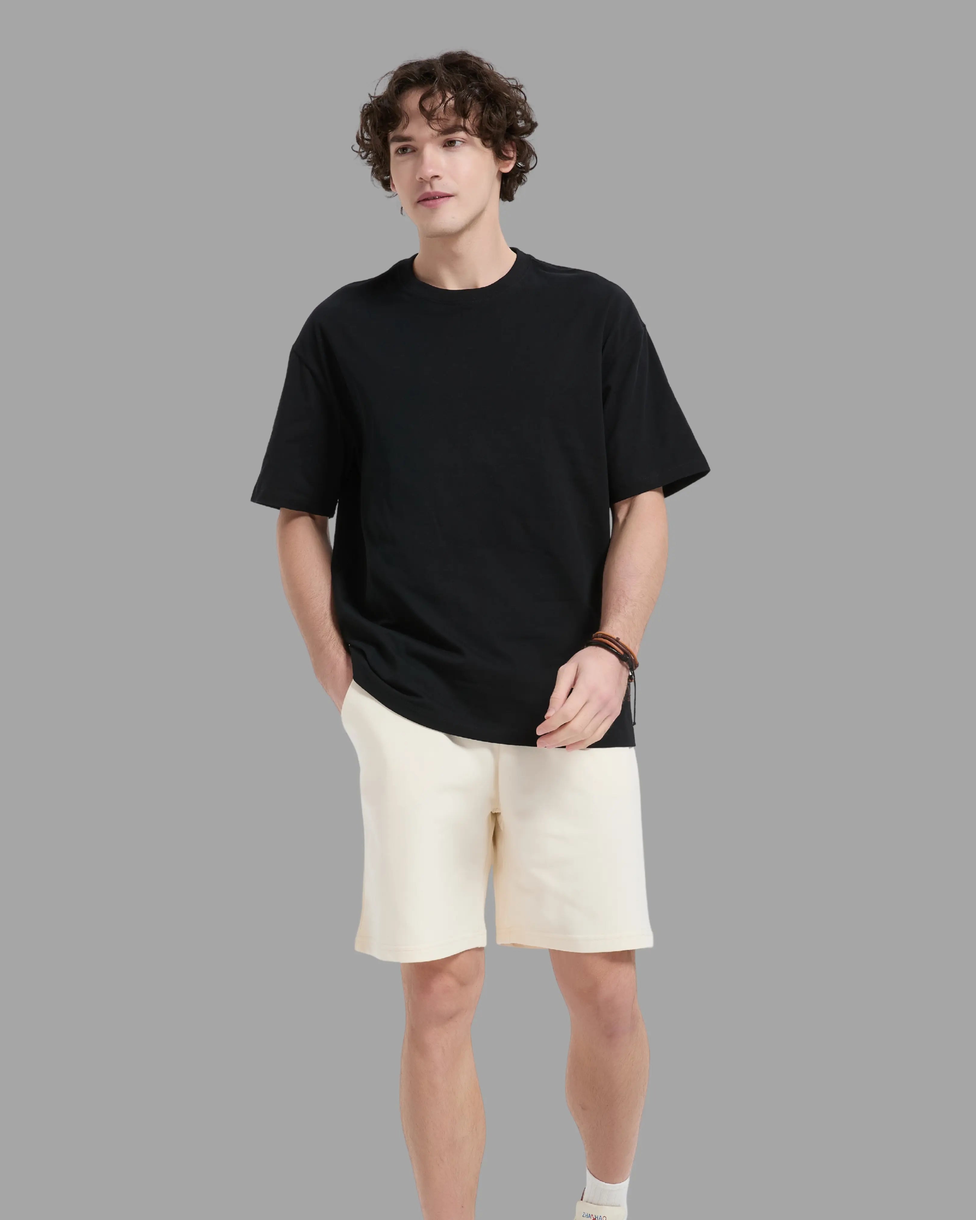 man wearing black t-shirt with oversized drop shoulder design, heavyweight 100% cotton fabric