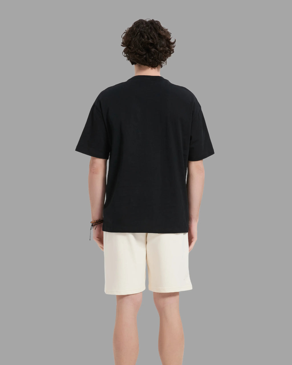man wearing black t-shirt with oversized drop shoulder design, heavyweight 100% cotton fabric
