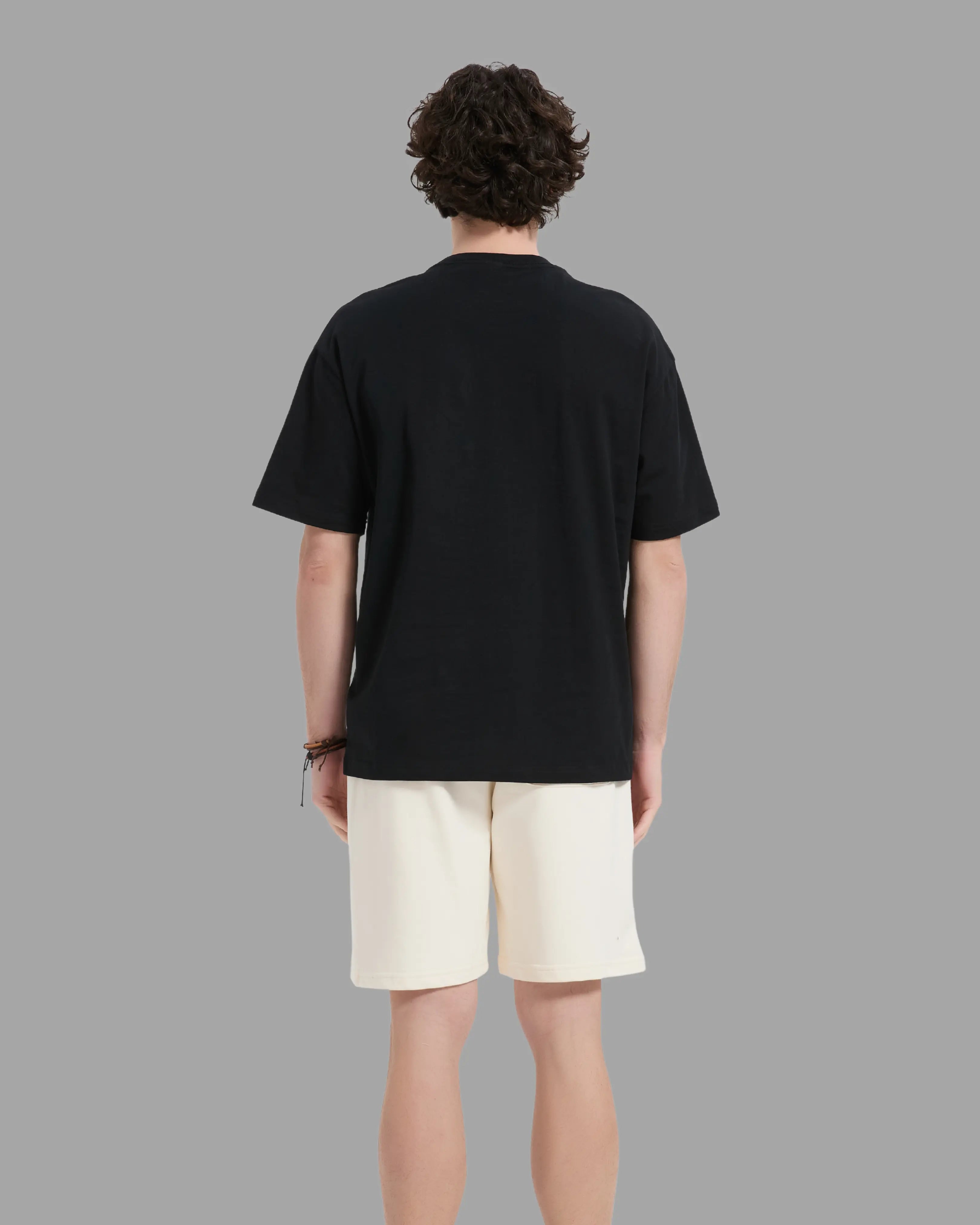 man wearing black t-shirt with oversized drop shoulder design, heavyweight 100% cotton fabric